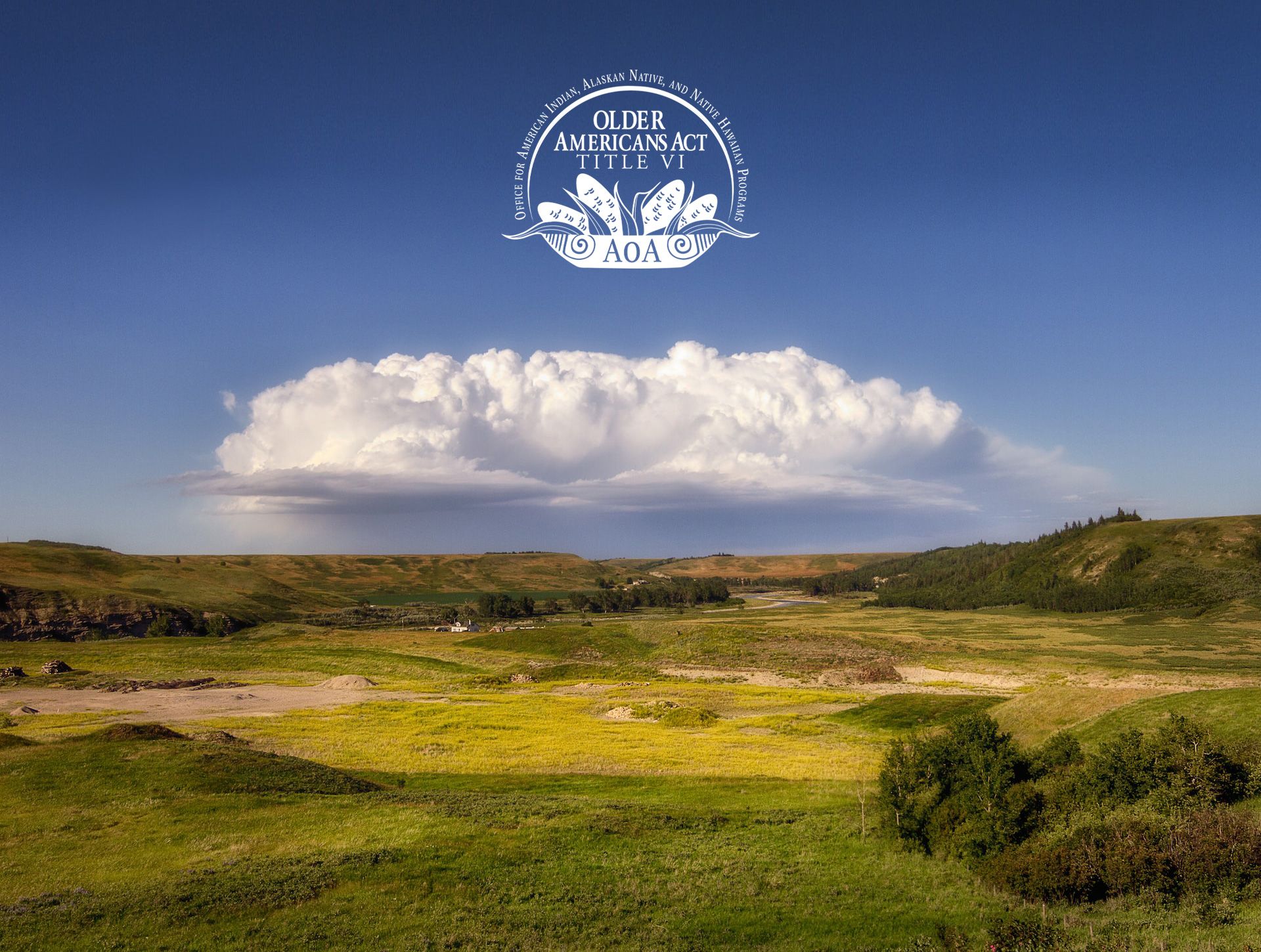 Dark blue sky with a single cloud rolling over fields of green